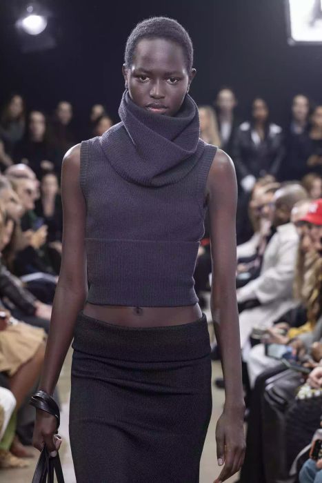 A model struts the Proenza Schouler runway in a tank top featuring a turtleneck and paired with a black skirt.