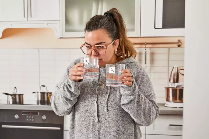 A person inhales the scent of water that has been filtered using the ZeroWater 12-Cup Ready-Pour 5-Stage Water Filter Pitcher
