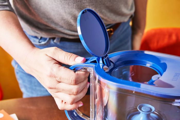 A person opens the lid of the Brita Tahoe Water Pitcher with Elite Filter