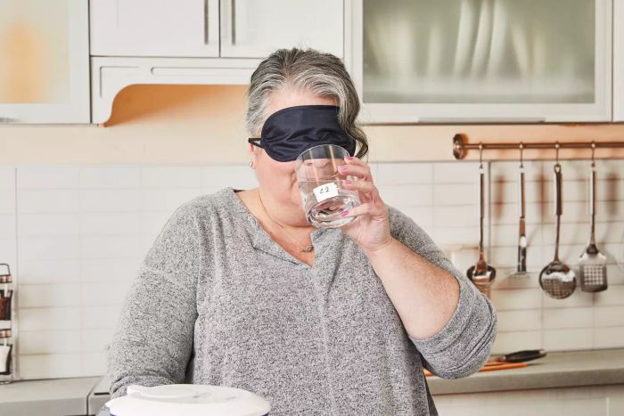 A person enjoys a glass of water filtered by the Pur Classic 11-Cup Water Filter Pitcher while blindfolded