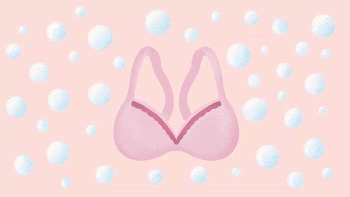 A Soft Pink Bra Illustrates the Concept, Set Against a Pale Pink Backdrop with Water Droplets