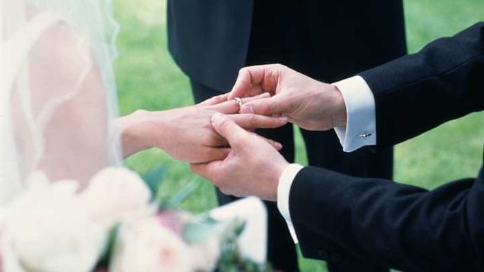 A bride and groom exchanging their wedding bands.
