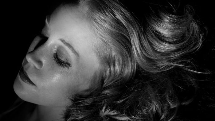 A classic black-and-white portrait of a woman, evoking vintage elegance.