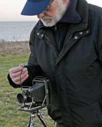 A person holding a cable release mechanism on an old-fashioned camera.&nbsp;