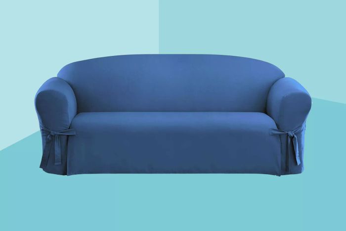 The SureFit Cotton Duck One-Piece Sofa Slipcover, set against a stylish blue backdrop