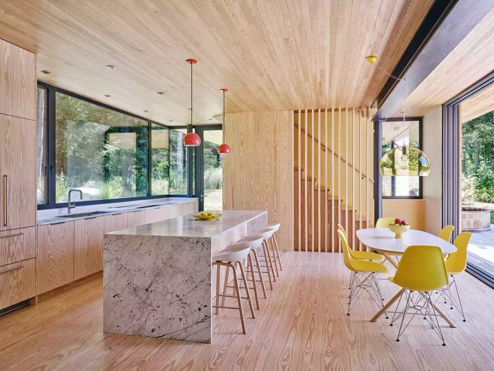 A wood-paneled kitchen and dining area featuring yellow dining chairs