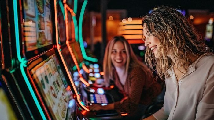 Two women enjoying their time at the arcade.