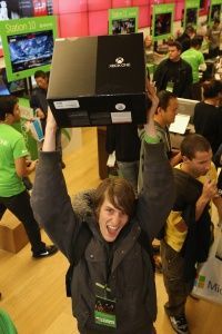 A fan from San Diego, California proudly displays his Xbox One purchase at a midnight release event.