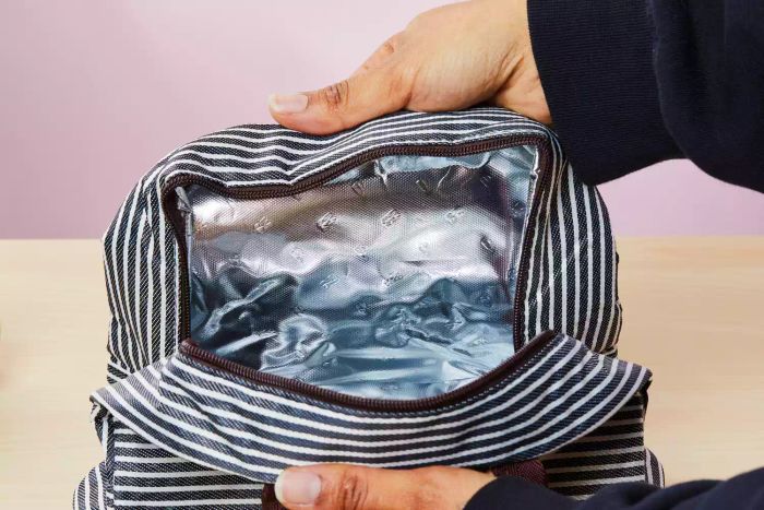 A person opening the Baloray Insulated Lunch Bag to reveal the inside of the bag