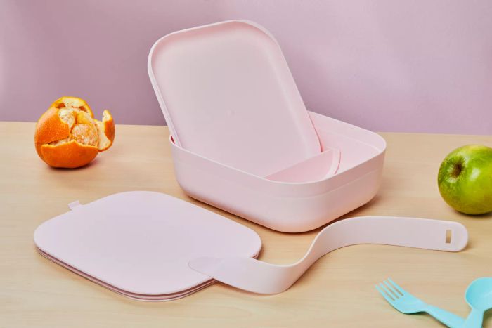 W&P Porter Lunch Box opened on a table with an orange, green apple, and cutlery