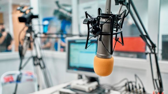 A close-up of a radio station microphone inside a recording studio, capturing the essence of audio production.