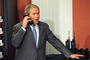 In 2008, U.S. President George W. Bush uses a walkie-talkie while touring World Wide Technology, Inc.