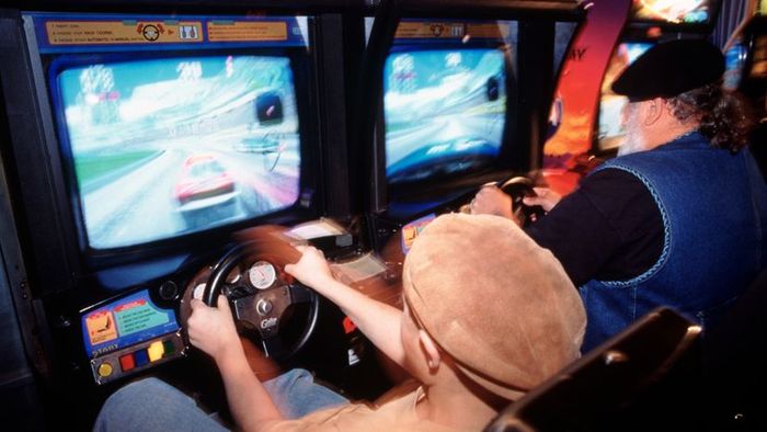 A child engaged in a video game at an arcade.