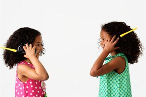 Two young girls chatting on walkie-talkies.