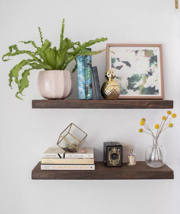 DIY floating shelves adorned with plants, artwork, and books