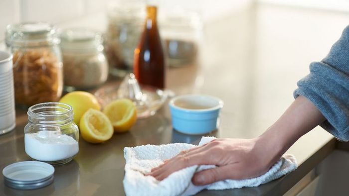 A woman cleaning a kitchen countertop