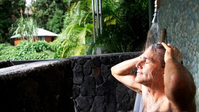 A person enjoying the refreshing experience of an outdoor shower.