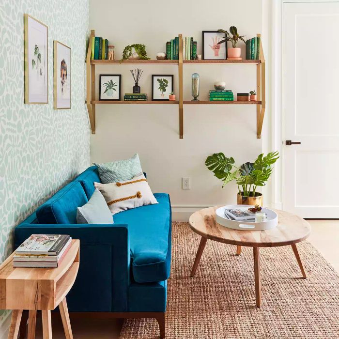 Living room featuring wooden wall shelves, a blue sofa, and a wooden coffee table.