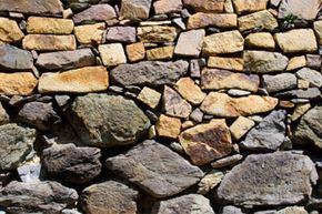 The layers of a dry stone wall, with larger stones positioned at the base