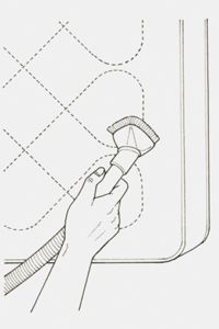 Illustration of a person using a hand vacuum to clean a mattress