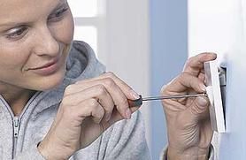 woman repairing a wall socket photo