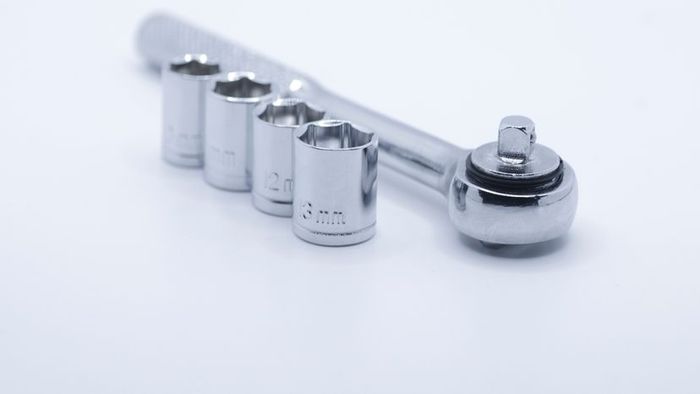 A socket wrench with an assortment of socket sizes displayed against a white backdrop.