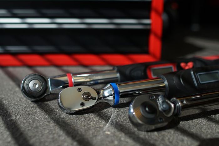 Three torque wrenches resting on a workbench.