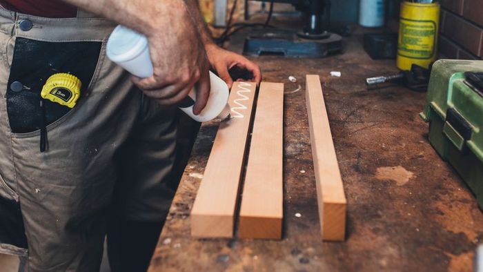 A man's hand working in a furniture workshop.