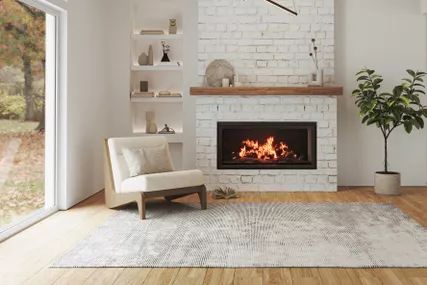Sophisticated living room with a fireplace, hardwood floors, elegant furniture, and vaulted ceiling
