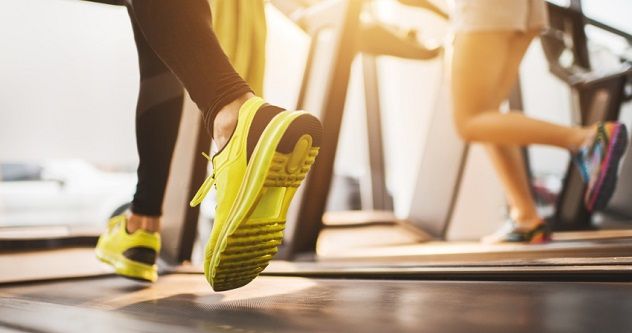 Anonymous individuals running on treadmills at a fitness center.