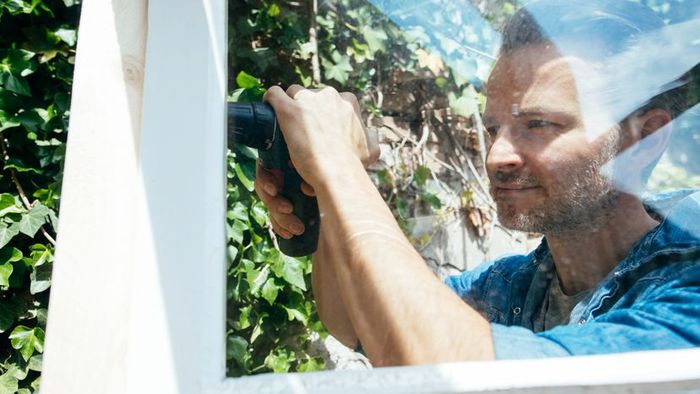 A person installing windows.