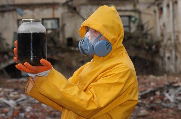 Man with protective mask and protective clothes explores danger