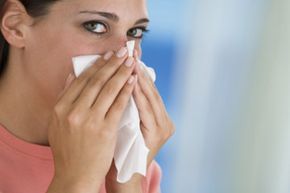 woman sneezing with tissue in hand