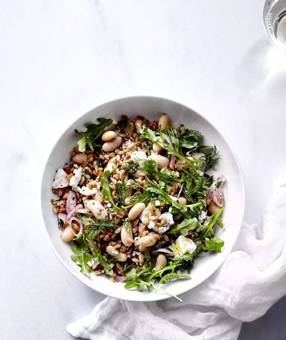 A serving of white bean and farro salad presented in a white bowl.