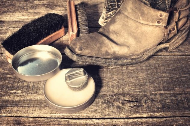 Shoe wax, boot brushes, and polish on a wooden surface
