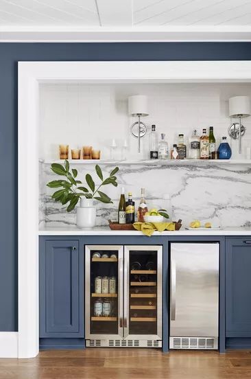A painted blue bar with a marble gray and white backsplash