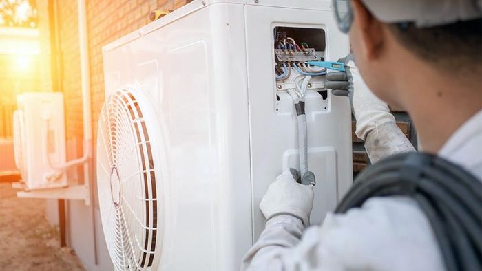 A technician servicing a heat pump