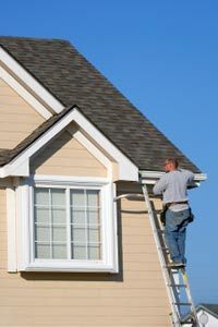A worker installs a section of extruded aluminum along the roofline of a house in Missouri.