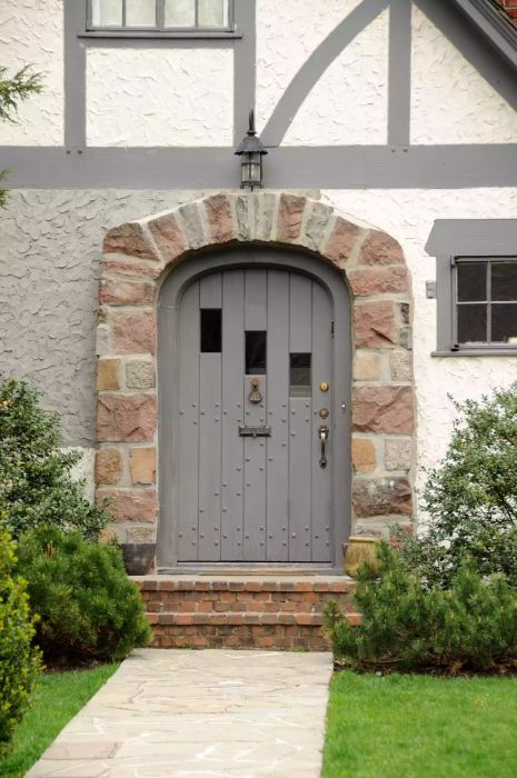 Gray door of a Tudor-style home.