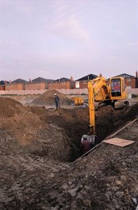A backhoe digs out a basement.