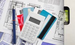 blueprints, credit cards, calculator, and other construction-related tools