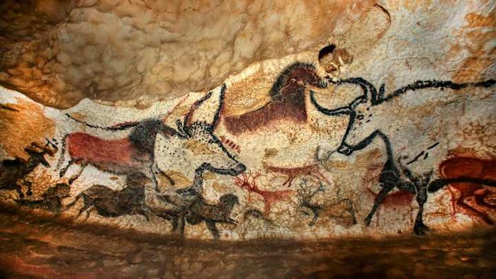 A reproduction of Paleolithic cave paintings depicting deer, horses, and aurochs, from around 15,000 BCE, located in the Lascaux cave in France.