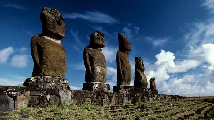 The Moai statues of Rapa Nui stand tall at Ahu Tahai, set against a backdrop of dramatic clouds.