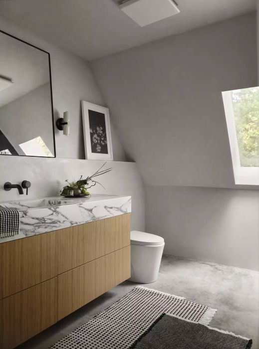 Bathroom with concrete floors, gray limewashed walls, and a wooden vanity with a marble countertop