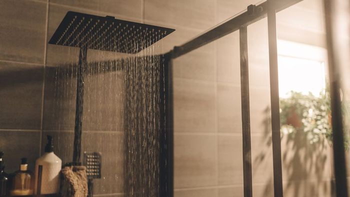 Close-up shot of water streaming from a shower head.