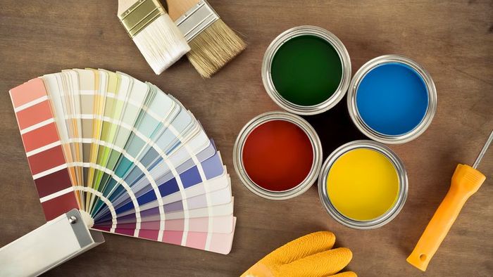 Four open paint cans, multiple swatches, two brushes, and other painting essentials