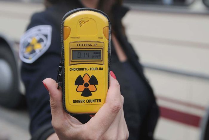 A woman holds a dosimeter.