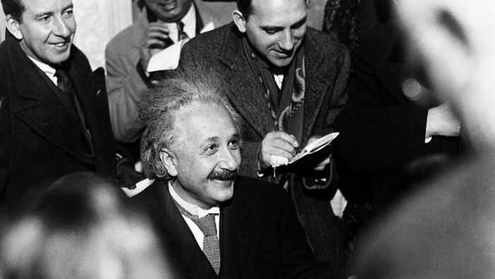 Albert Einstein responding to questions from reporters.
