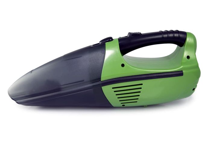 A green and black cordless handheld vacuum set against a white background.