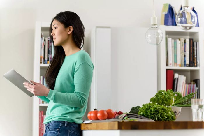 Woman Cooking in the Kitchen with Cookbooks